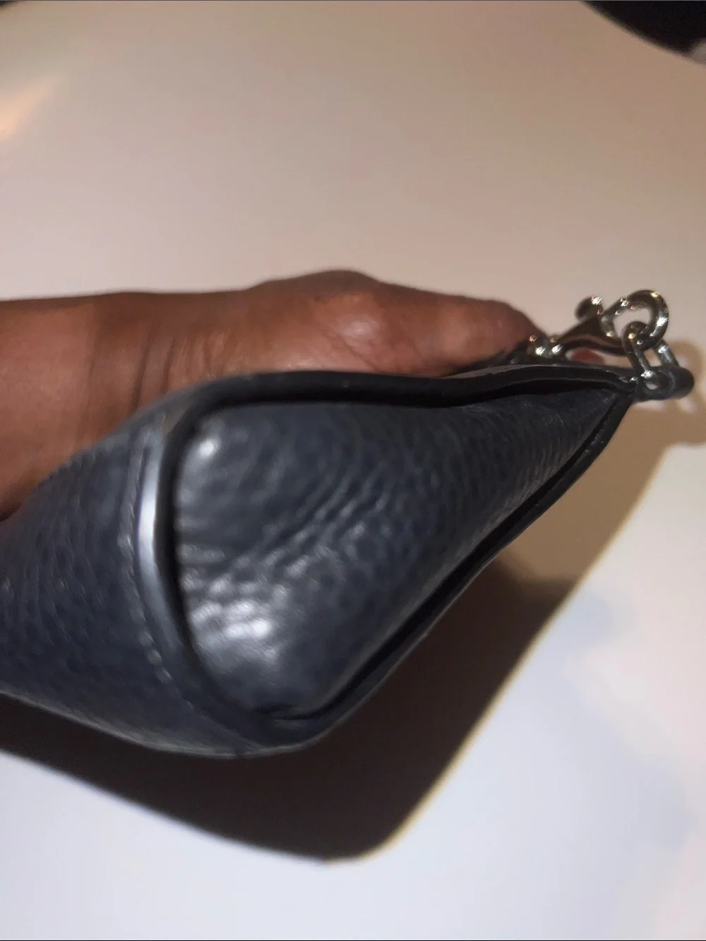 Coach Black Pebbled Leather Wristlet featuring silver hardware and a top zipper.